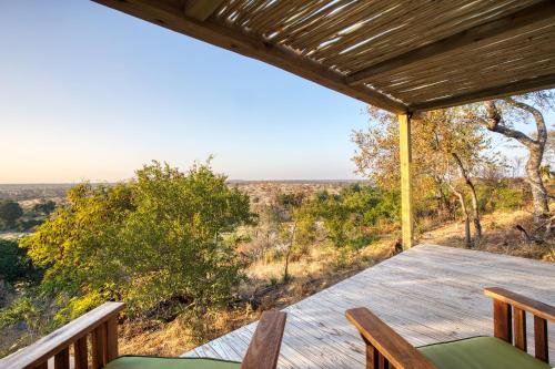 a wooden deck with a table and chairs on a porch at Klaserie Drift Misava in Klaserie Private Nature Reserve