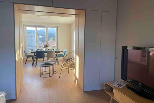 un salon avec une table à manger et une télévision dans l'établissement Appartement spacieux et lumineux, à Aix-les-Bains