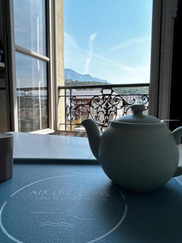 une théière assise sur une table devant une fenêtre dans l'établissement Le Centr’Aix-Studio au cœur d’Aix-les-Bains, à Aix-les-Bains