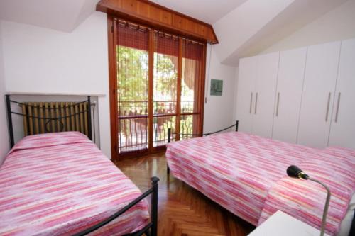 une chambre avec deux lits et une fenêtre dans l'établissement 62 Villa Vespucci Evangelisti Casa, à Bellaria-Igea Marina