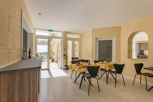 a kitchen and living room with a table and chairs at Ta'Battista B&B with pool - Gozo in Xewkija