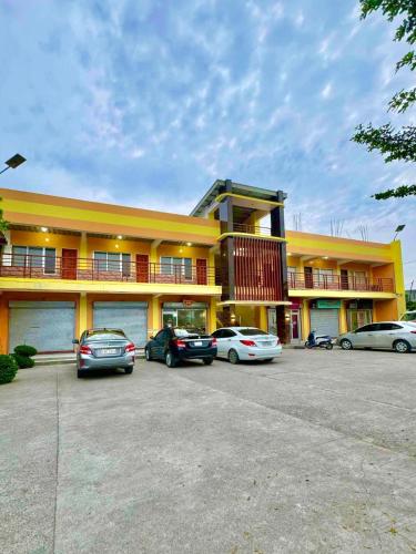 a yellow building with cars parked in a parking lot at CEEJ Building Transient Studio Rooms in Iloilo City
