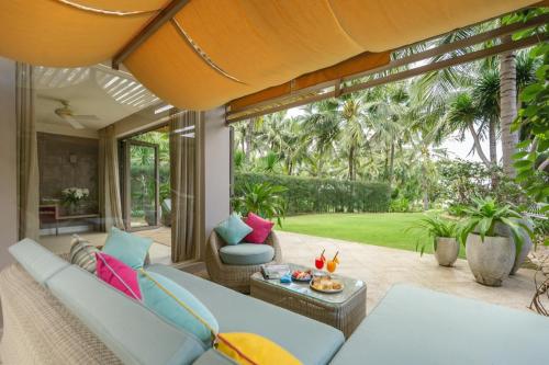 an outdoor patio with a couch and chairs and a table at Mia Resort Nha Trang in Nha Trang