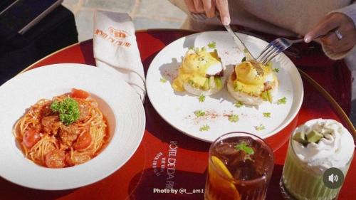 a table with two plates of food and a drink at Hôtel De Da Phu in Da Lat