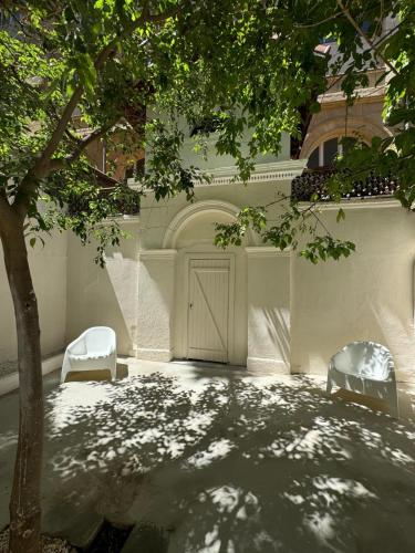 deux chaises et une porte dans un bâtiment avec un arbre dans l'établissement Maison Senac - Boutique hôtel, à Marseille