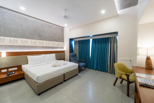 a hotel room with a bed and a desk and a chair at Shilton Dee Cee in Chennai