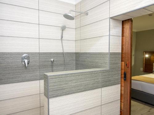 a shower in a bathroom with a glass wall at The Lazy Moose Restaurant and Lodge in Clansthal