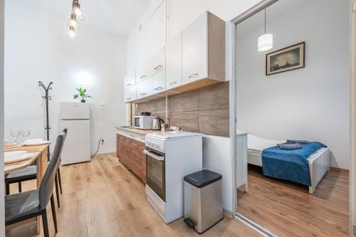 cocina con armarios blancos, mesa y comedor en M&M Apartment - Ferenciek tere, en Budapest