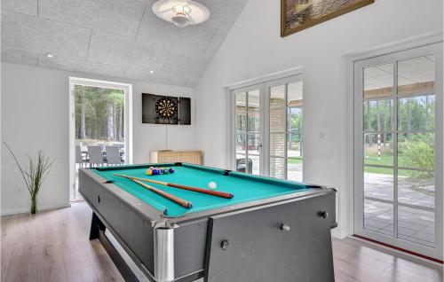 a room with a pool table with bats on it at Lovely Home In Ulfborg With Sauna in Øhuse