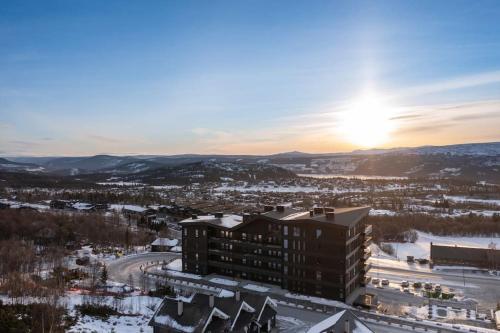 a view of a building with the sunset in the background at Riddertunets stilfulle in Beitostøl