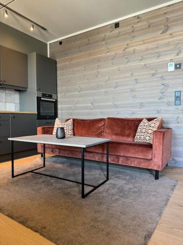 a living room with a couch and a table at Riddertunets stilfulle in Beitostøl