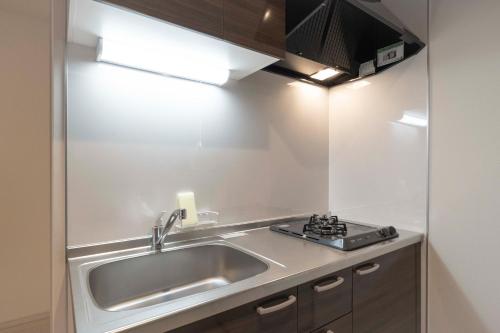 a kitchen with a sink and a stove at Rufura Fukusima in Osaka