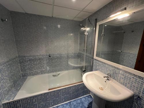 a bathroom with a tub and a sink and a mirror at La Casita Azul in San José