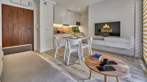 a living room and kitchen with a table and chairs at Źródło Izery przy gondoli VIP Sauna, Siłownia, Bawialnia by Royal Aparts in Świeradów-Zdrój