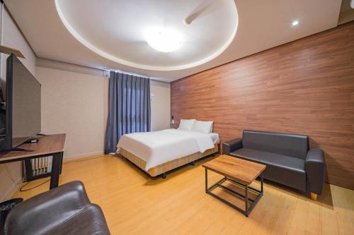 a hotel room with a bed and a couch at Incheon Airport Hotel Seattle in Incheon