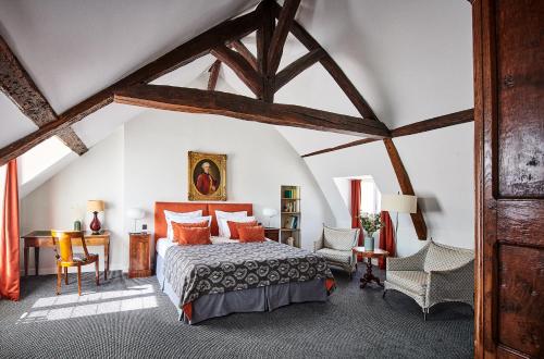 a bedroom with a bed and a table and chairs at Hôtel d'Orsay - Esprit de France in Paris