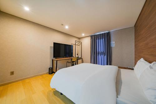a bedroom with a bed and a flat screen tv at Incheon Airport Hotel Seattle in Incheon