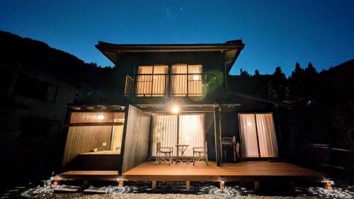 a house with a deck with a table and chairs at 下呂スプリングスロッジ in Gero