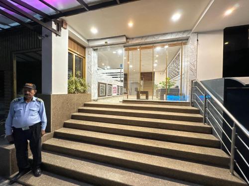 a man standing on the stairs of a building at Hotel Chandigarh Grand and Banquet in Manī Mājra