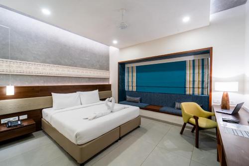 a hotel room with a bed and a desk and a window at Shilton Dee Cee in Chennai