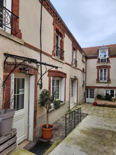 a courtyard of a building with a door and a plant at Appartement avec baignoire - Hautvillers in Hautvillers