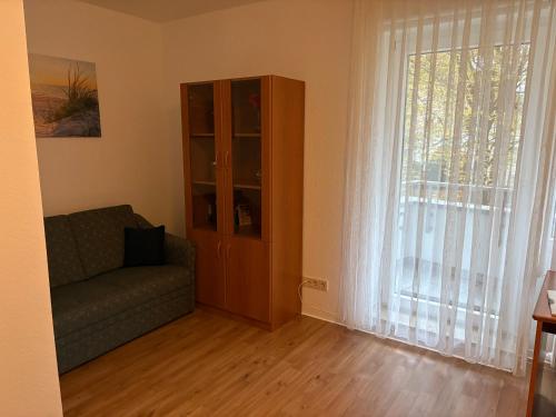 a living room with a couch and a large window at Komfort Appartement Bad Pyrmont Nähe Kurpark in Bad Pyrmont
