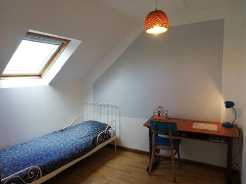 une chambre avec un lit, un bureau et une fenêtre dans l'établissement Gîte nature proche Saint Malo, à Miniac-Morvan