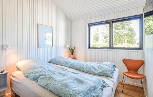 a bedroom with two beds with blue blankets and a chair at Three-Bedroom Holiday Home In Juelsminde in Juelsminde
