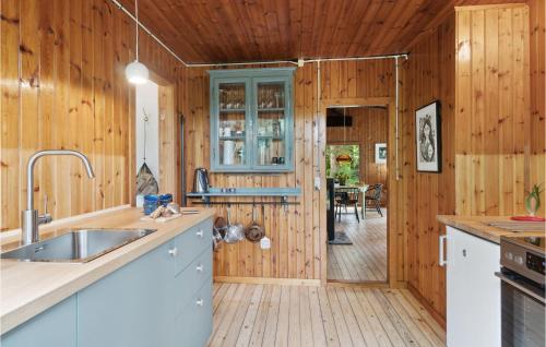 a kitchen with wooden walls and a wooden floor at 2 Bedroom Gorgeous Home In Jægerspris in Jægerspris