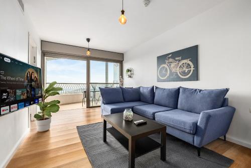 a living room with a blue couch and a table at pisgat shoresh in Shoresh
