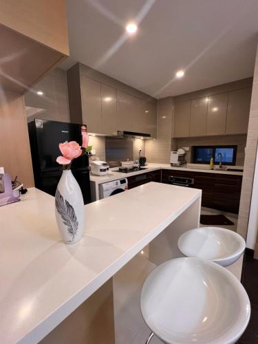 a kitchen with a white vase with flowers on a counter at R&F Princess Cove View Residences by WSD in Johor Bahru