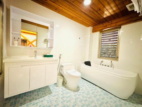 a bathroom with a toilet and a sink and a tub at Ivy Motel in Chiayi City