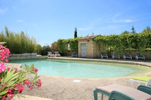 une piscine avec des chaises et une maison dans l'établissement Gîte 6-8 pers dans Mas provençal avec piscine et jardin, à Villedieu
