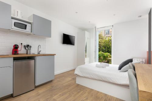 une chambre blanche avec un lit et une cuisine dans l'établissement STUDIOS cosy au centre-ville quartier Jaurès et Saint-Martin, à Brest
