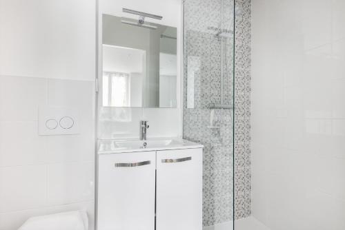 une salle de bain blanche avec un lavabo et un miroir dans l'établissement STUDIOS cosy au centre-ville quartier Jaurès et Saint-Martin, à Brest