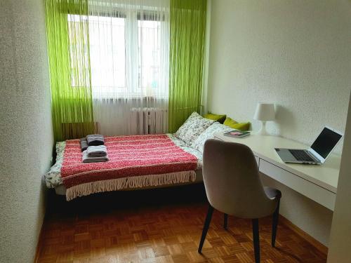 a bedroom with a bed with a desk and a laptop at Wygodny dwupokojowy apartament pomiedzy lotniskiem a centrum in Warsaw