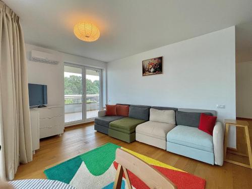 a living room with a couch and a tv at Apartment No 207 Lebada Lake Residence in Pantelimon