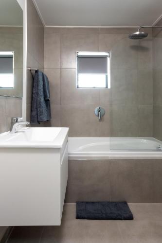 a bathroom with a white tub and a sink at Perfect View 204 Mossel Cove in Mossel Bay