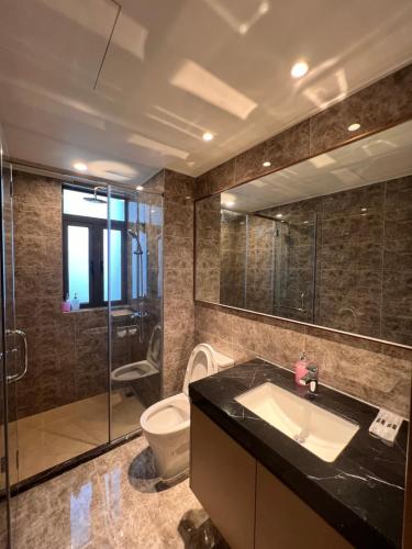 a bathroom with a sink and a toilet and a glass shower at R&F Princess Cove View Residences by WSD in Johor Bahru