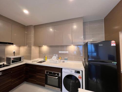 a kitchen with a black refrigerator and a dishwasher at R&F Princess Cove View Residences by WSD in Johor Bahru
