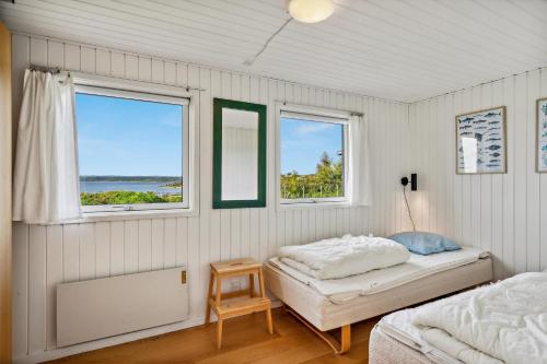Un dormitorio con dos camas y dos ventanas. en Stunning Home In Ebeltoft With 3 Bedrooms And Internet, en Ebeltoft