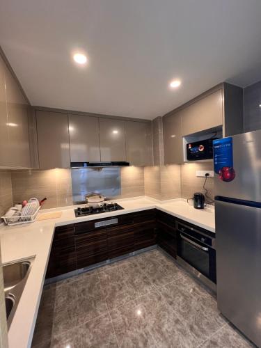 a kitchen with stainless steel appliances and brown cabinets at R&F Princess Cove View Residences by WSD in Johor Bahru
