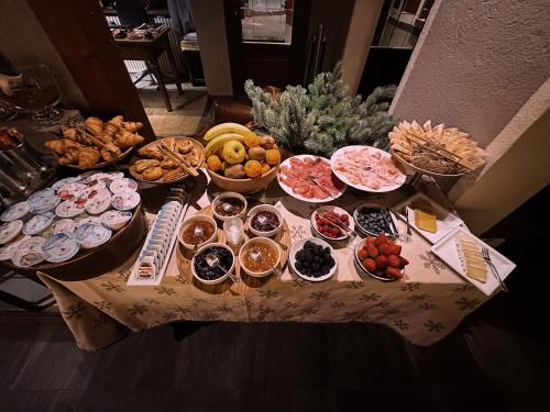 a table with many different types of food on it at Le Samovar Guest House in Breuil-Cervinia