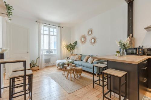 Il comprend une cuisine et un salon doté d'un canapé bleu. dans l'établissement Duplex des Halles 3 chambres, à Pau