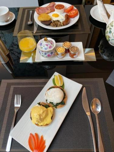 two plates of food on a table with breakfast foods at Derby Manor in Bournemouth