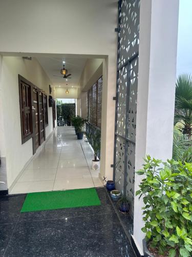 a hallway of a house with a green mat at SS Farms Hotel & Resort in Sonīpat
