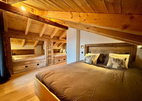 a bedroom with a large bed with wooden ceilings at Chalet traditionnel Haute Nendaz in Nendaz