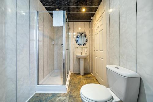 a bathroom with a shower and a toilet and a sink at Bluewaters Hotel Blackpool in Blackpool