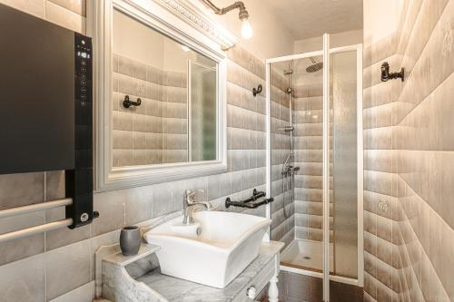 une salle de bain blanche avec un lavabo et une douche dans l'établissement Le Logis De La Sicarde, à Saint-Denis-dʼOléron