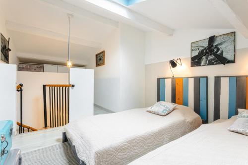 deux lits dans une chambre aux murs blancs dans l'établissement Le Logis De La Sicarde, à Saint-Denis-dʼOléron